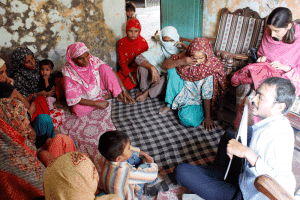 A loan officer conducts a focus group at a Kashf client's home